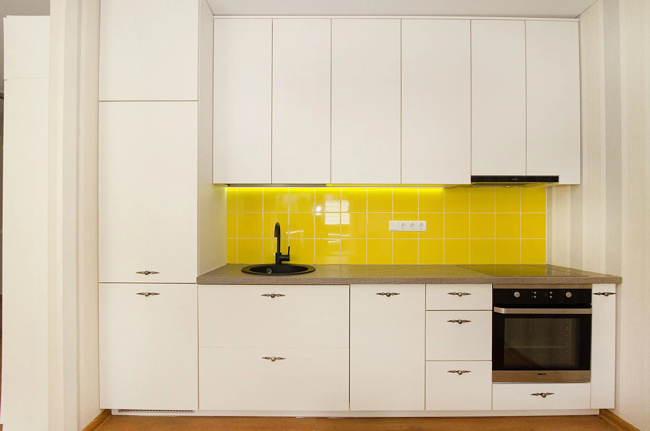 modern kitchen cabinet pulls Stylish modern kitchen with white cabinets and a vibrant yellow tile backsplash.