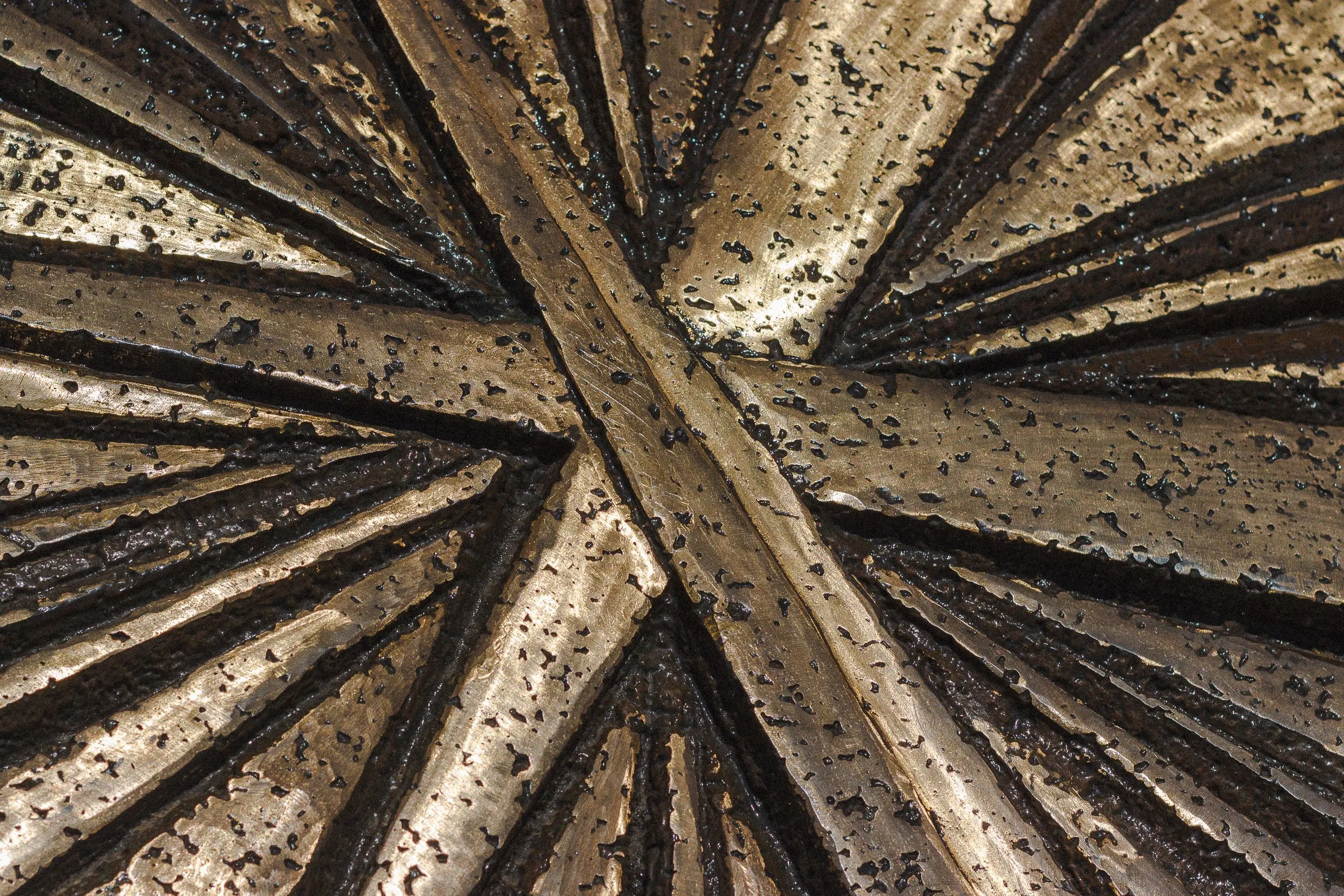 large exterior metal wall art Detailed close-up of a textured metallic surface with geometric patterns and earthy tones.