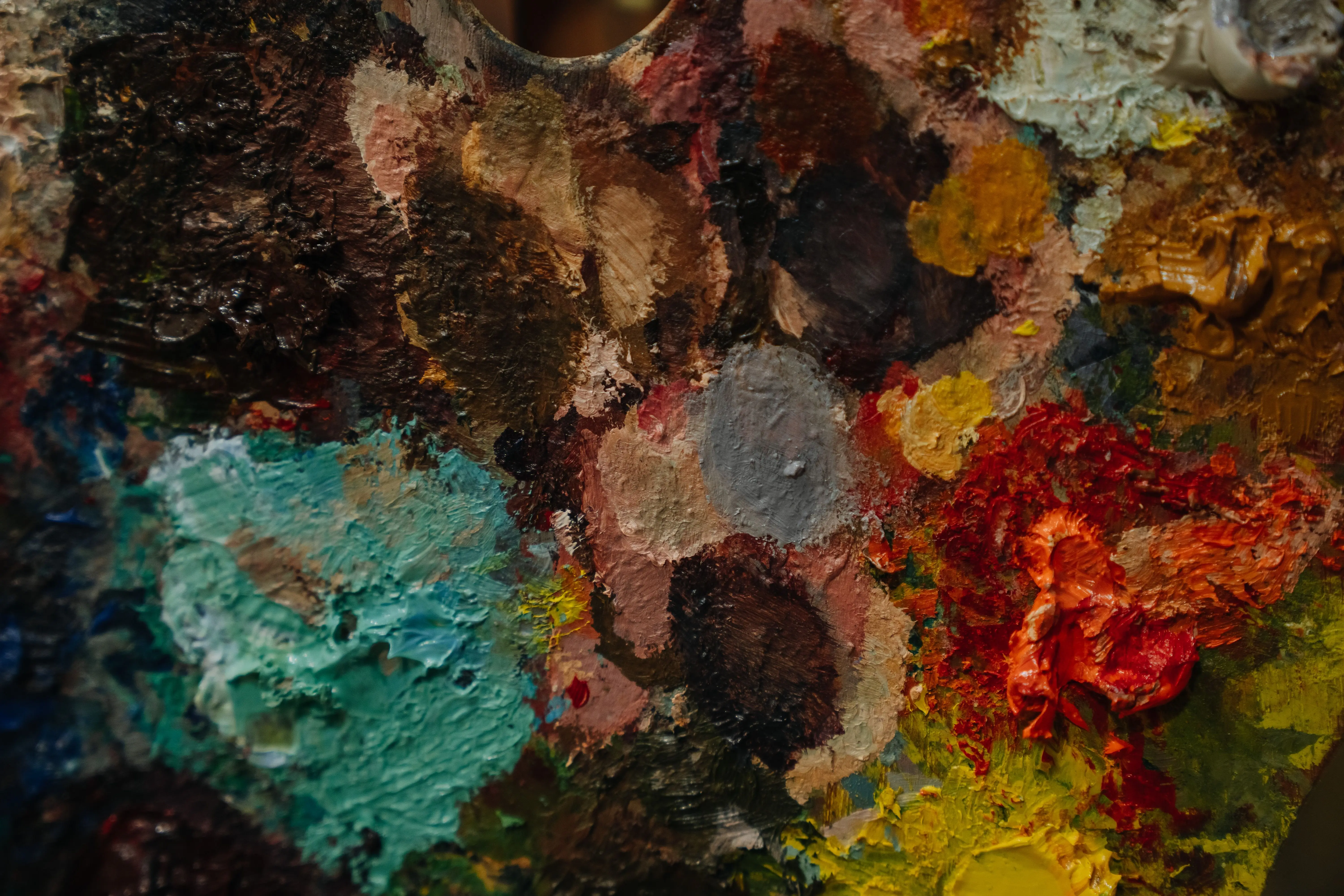 paint inspo Close-up of a colorful artist's palette with various paint blobs and textures.