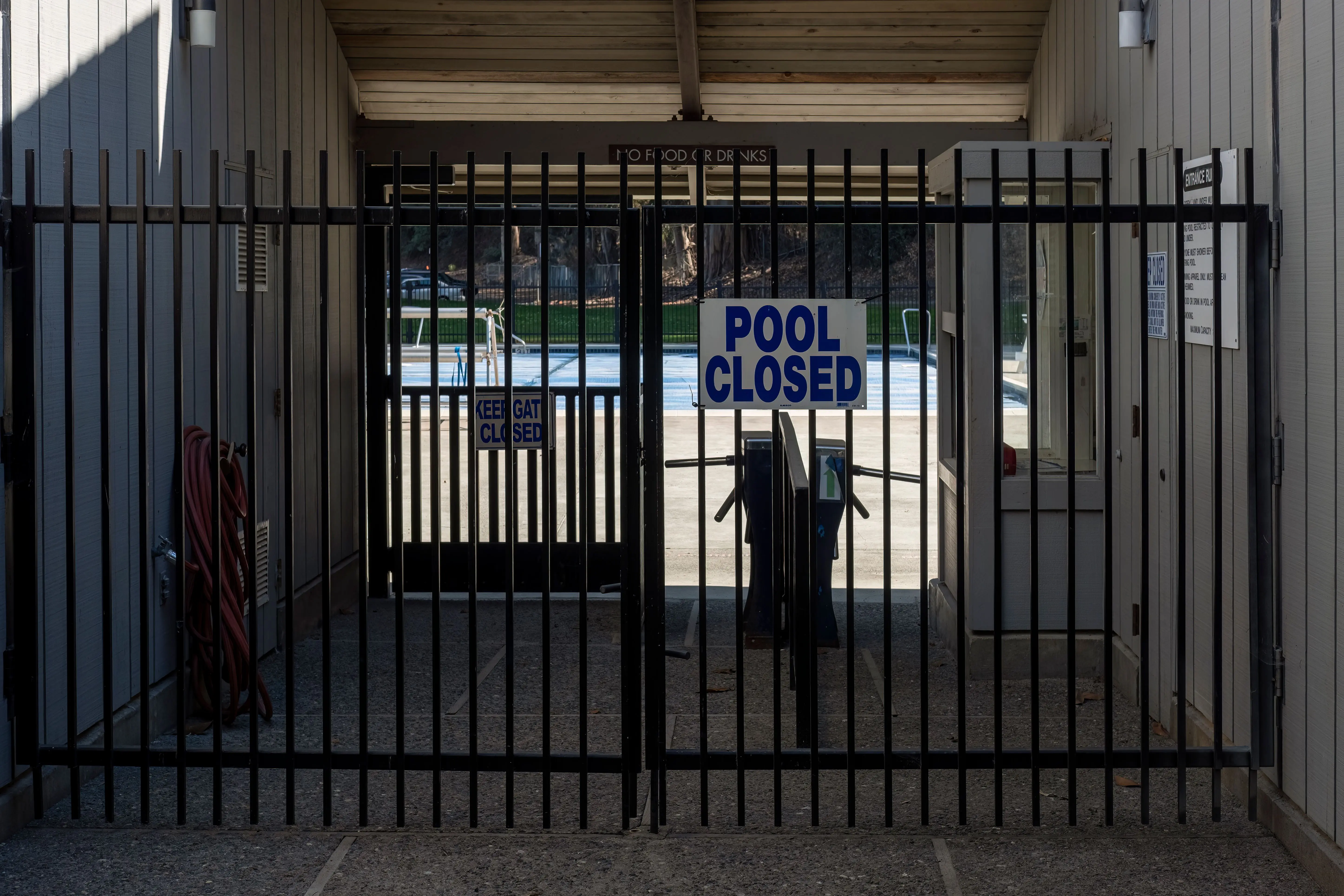 pool gates Iron gate blocking a closed community pool entrance with a clear sign.