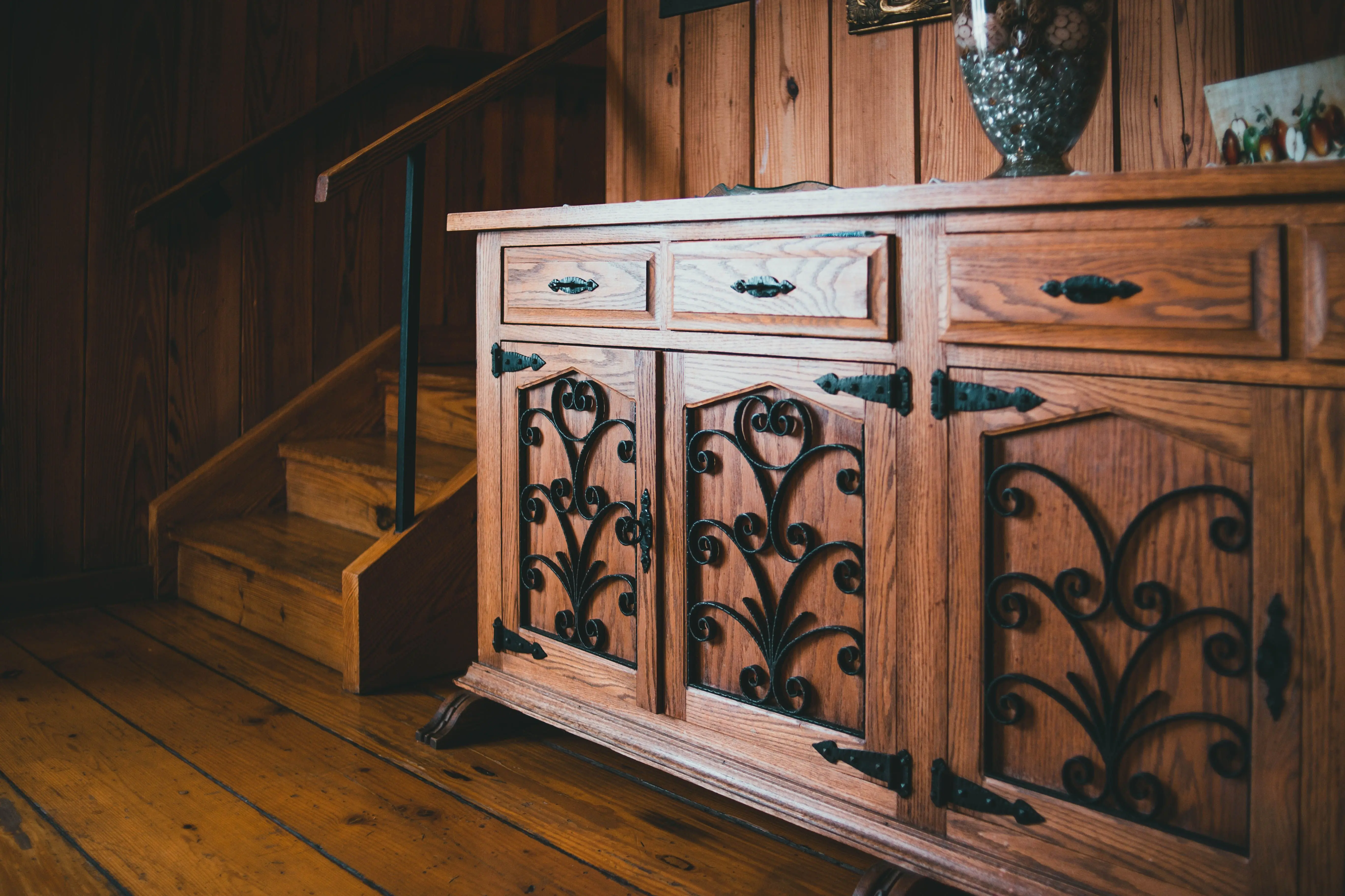 rustic cabinets Warm wooden sideboard and staircase in a cozy, rustic interior.