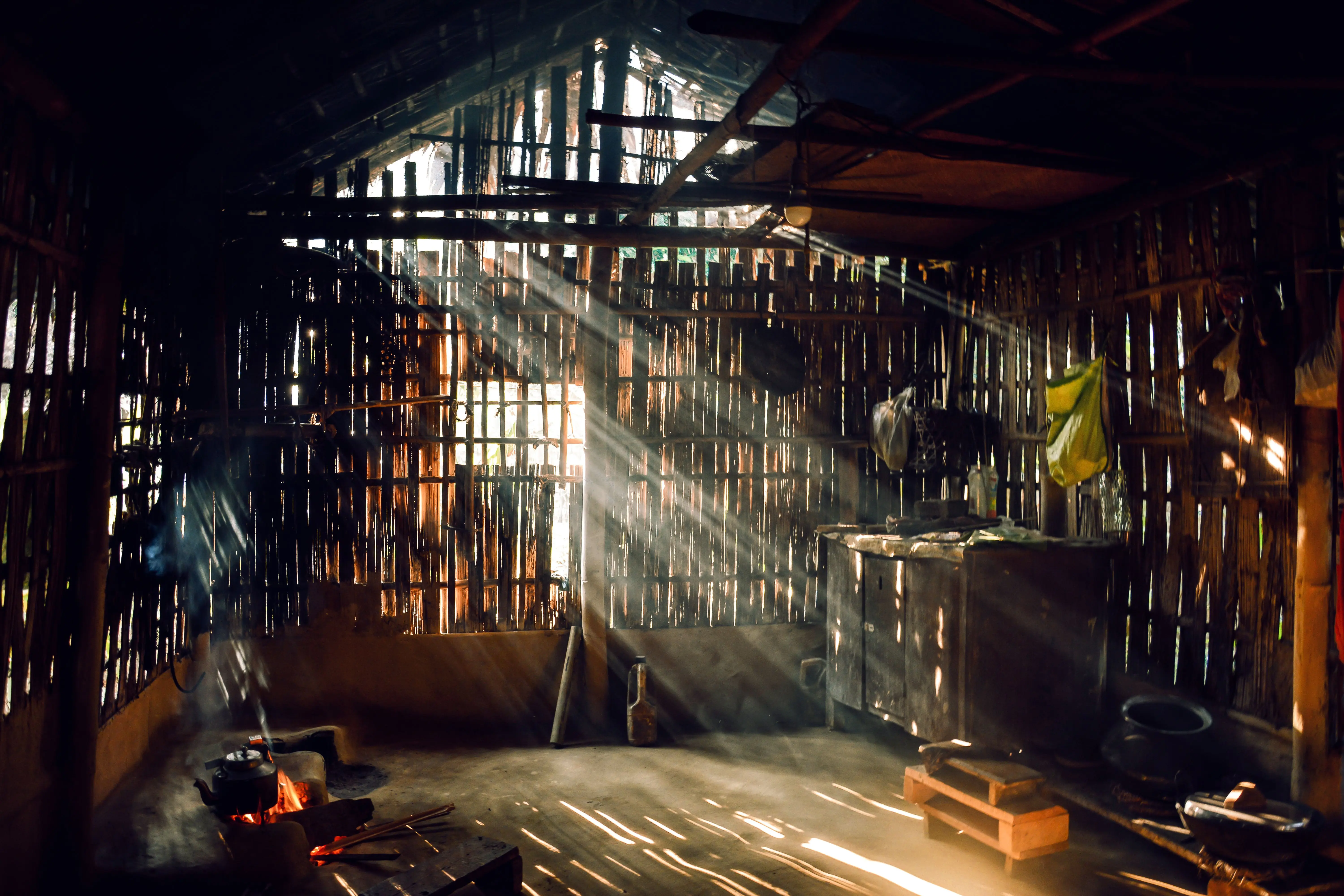 rustic cabinets Sunlight streaming through a rustic bamboo hut creating a warm, serene atmosphere.