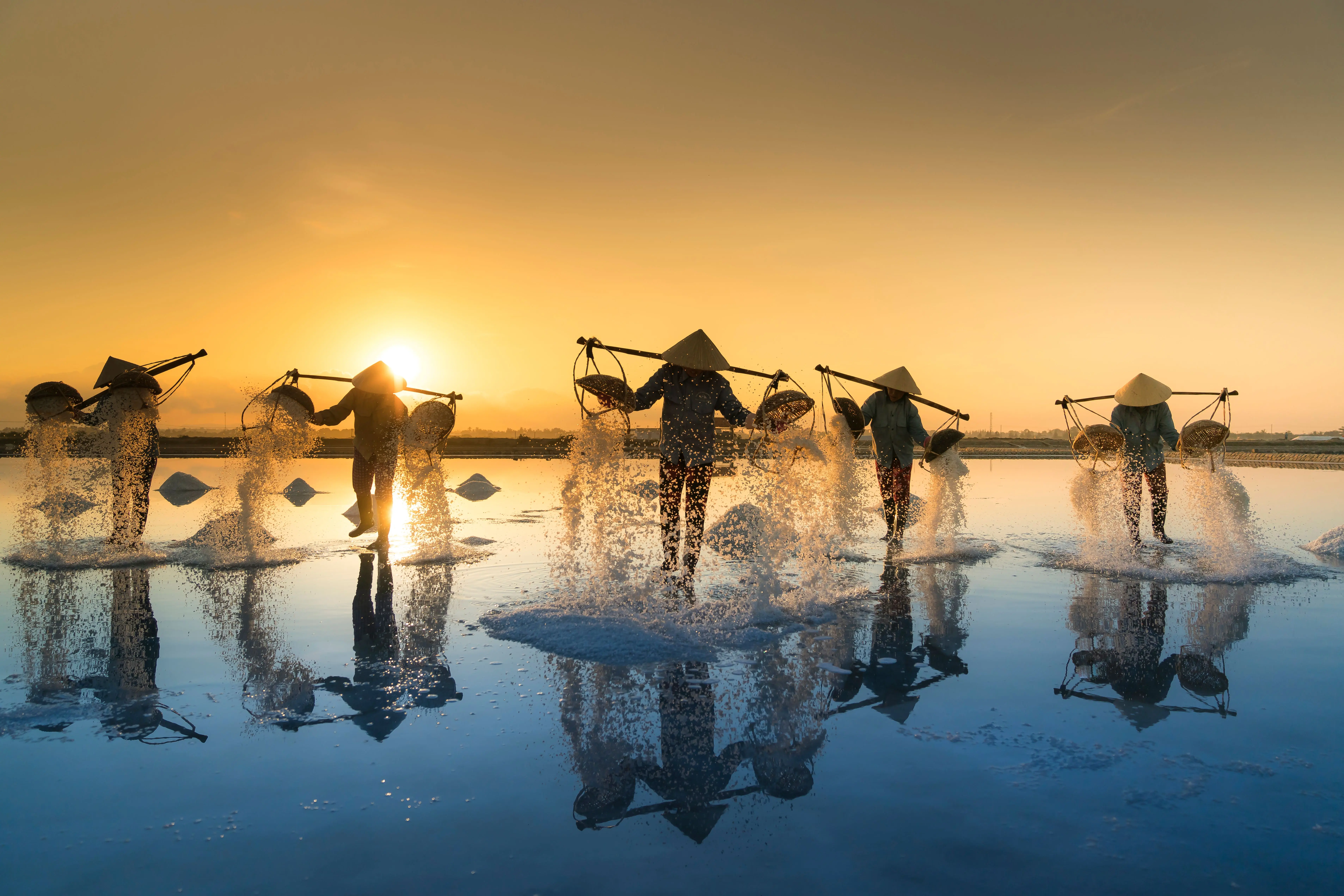 how to get blood off sheets Fishermen collecting salt at sunset, reflecting in water, showcasing traditional methods.