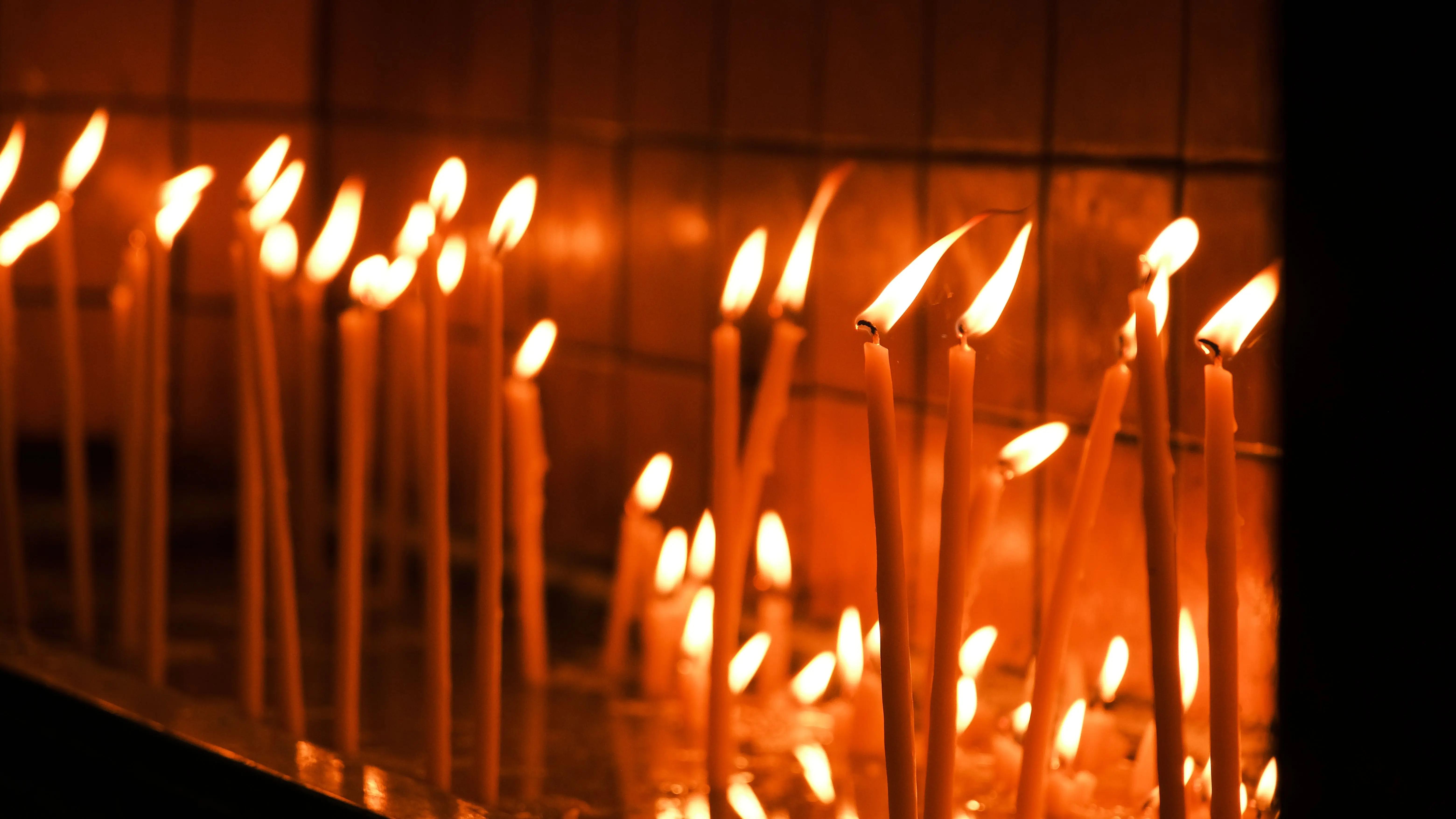 tapered candle holders A serene image of tall candles glowing warmly in a dimly lit room, creating a peaceful ambience.