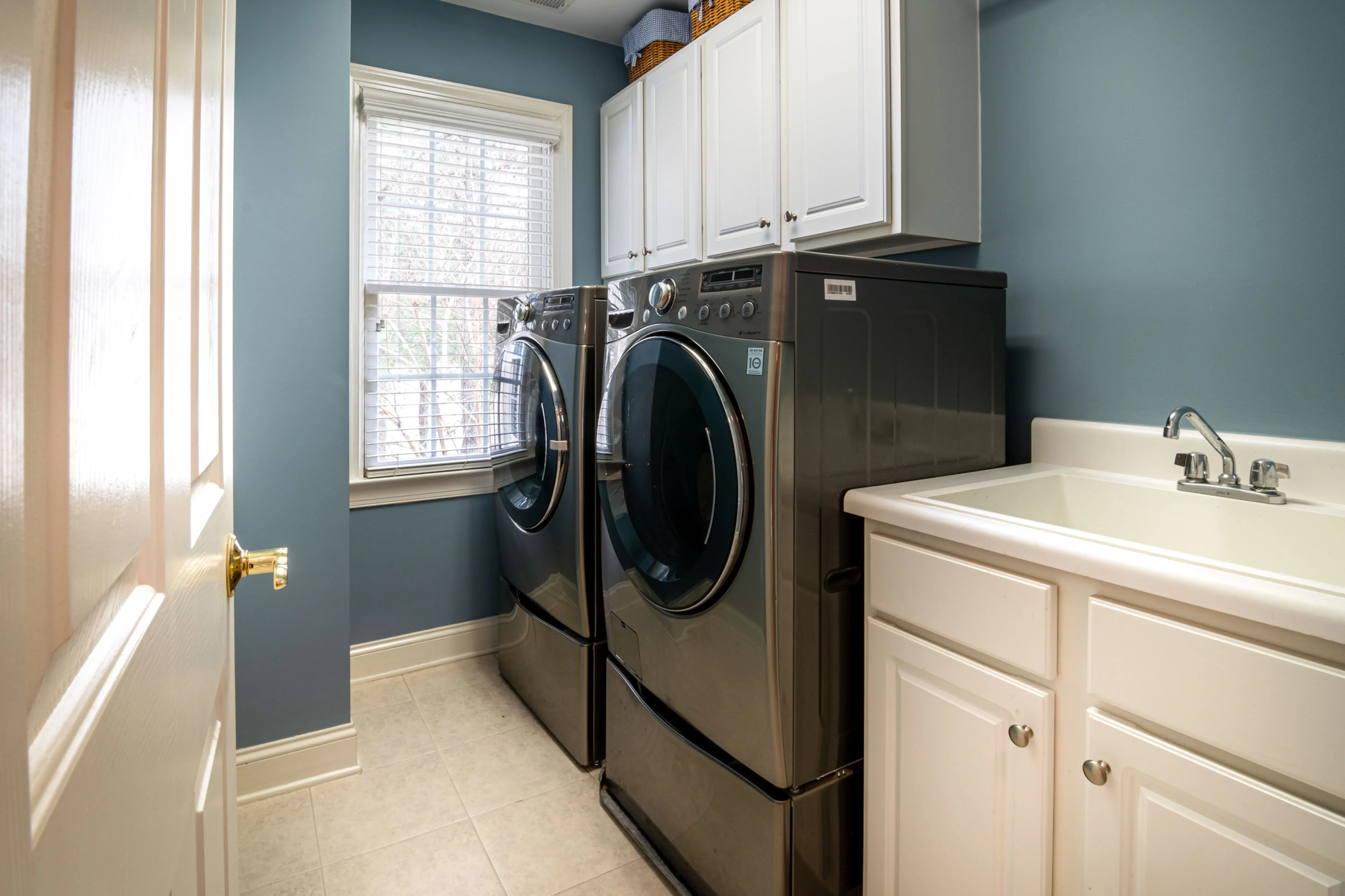 washer sizes A clean, organized laundry room featuring modern appliances and ample storage.