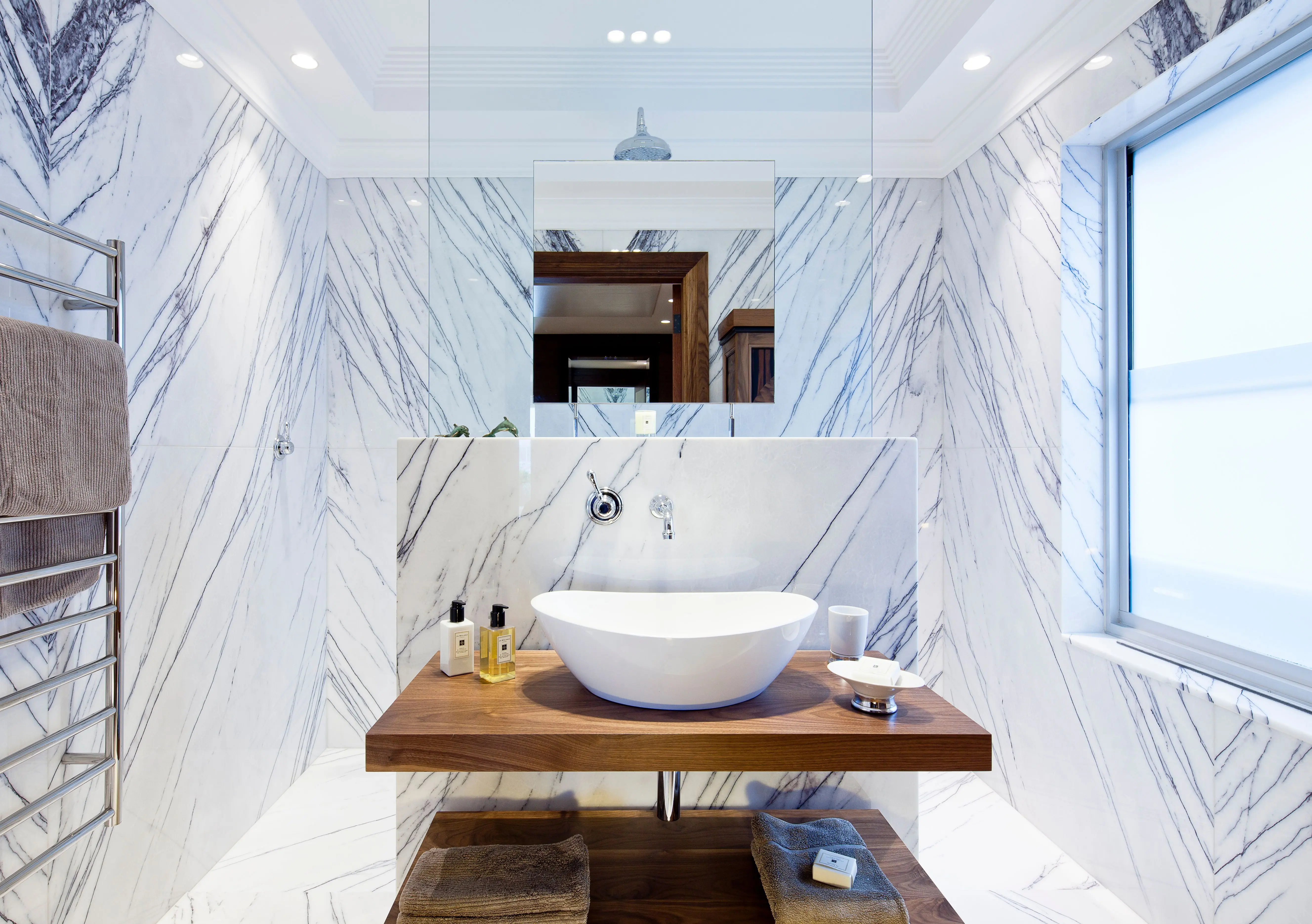 towel shelf Contemporary bathroom design featuring marble walls and modern sink.