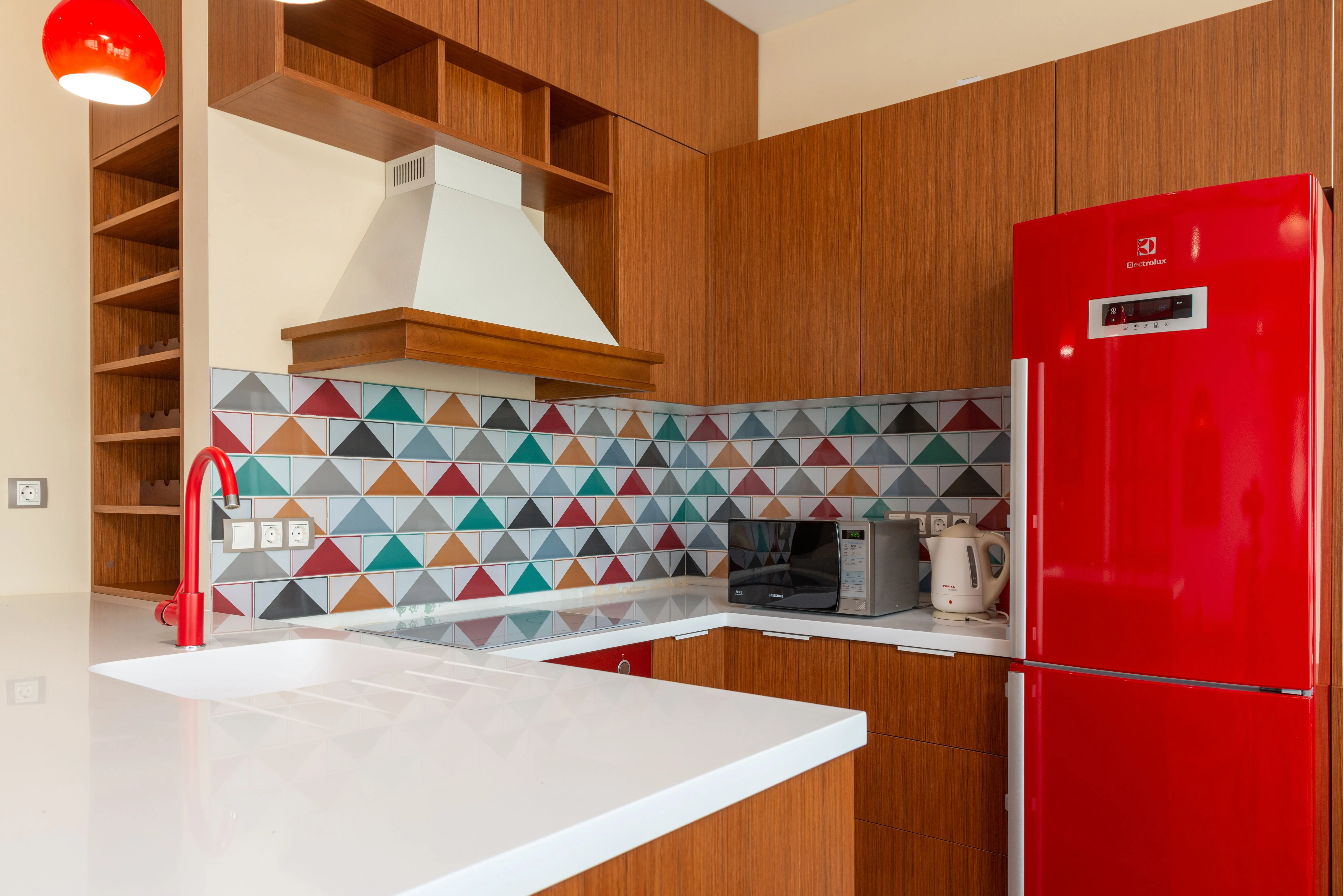 contemporary kitchen backsplash Contemporary kitchen design featuring colorful geometric tiles and red appliances.