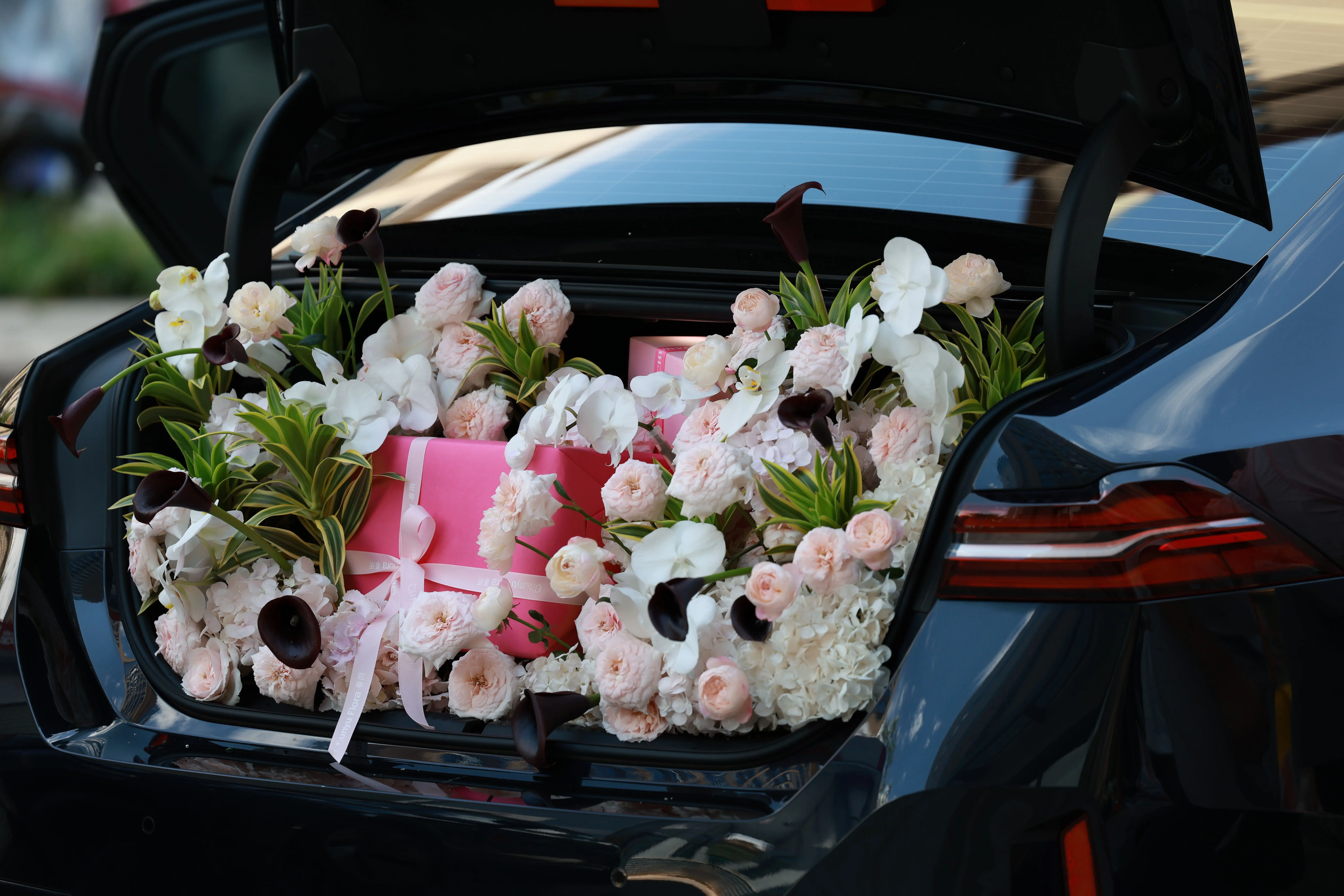 gerbera flower bouquet A beautiful floral arrangement with pink gifts in a car trunk, perfect for a celebration.