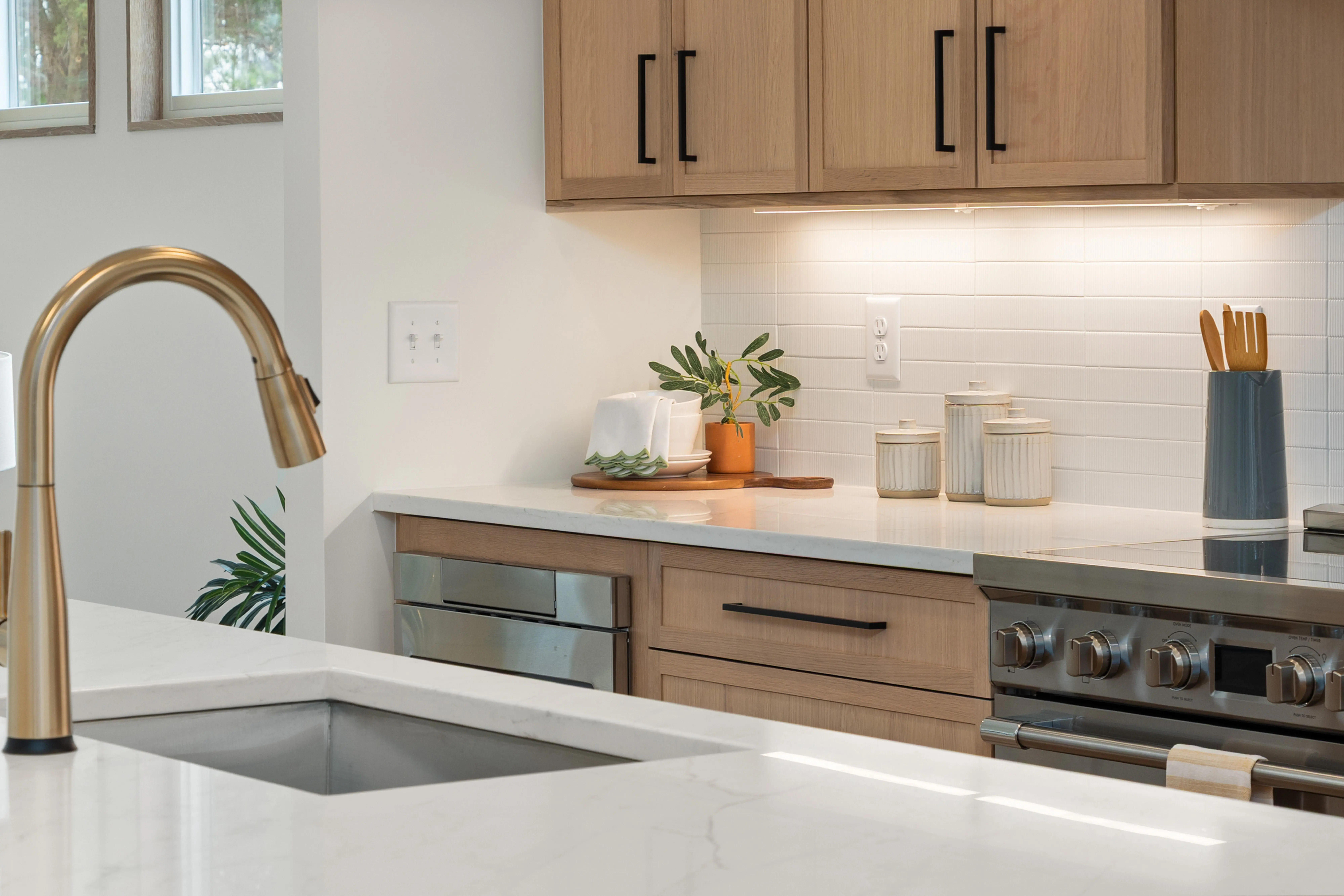 contemporary kitchen backsplash Elegant modern kitchen featuring marble countertops, wooden cabinets, and brass fixtures.
