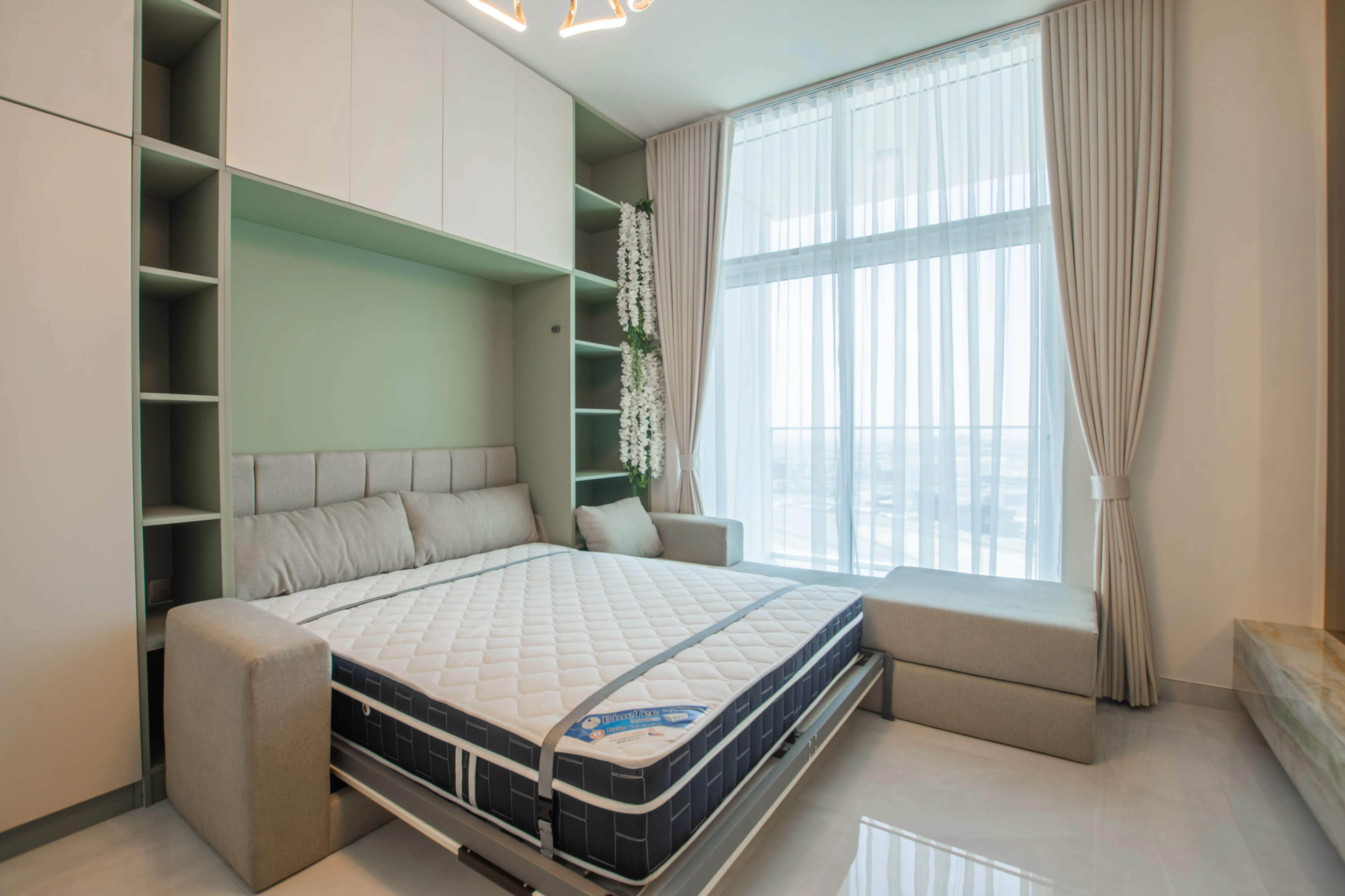 bed desk combo Stylish bedroom featuring a pull-down Murphy bed, elegant curtains, and bright lighting.