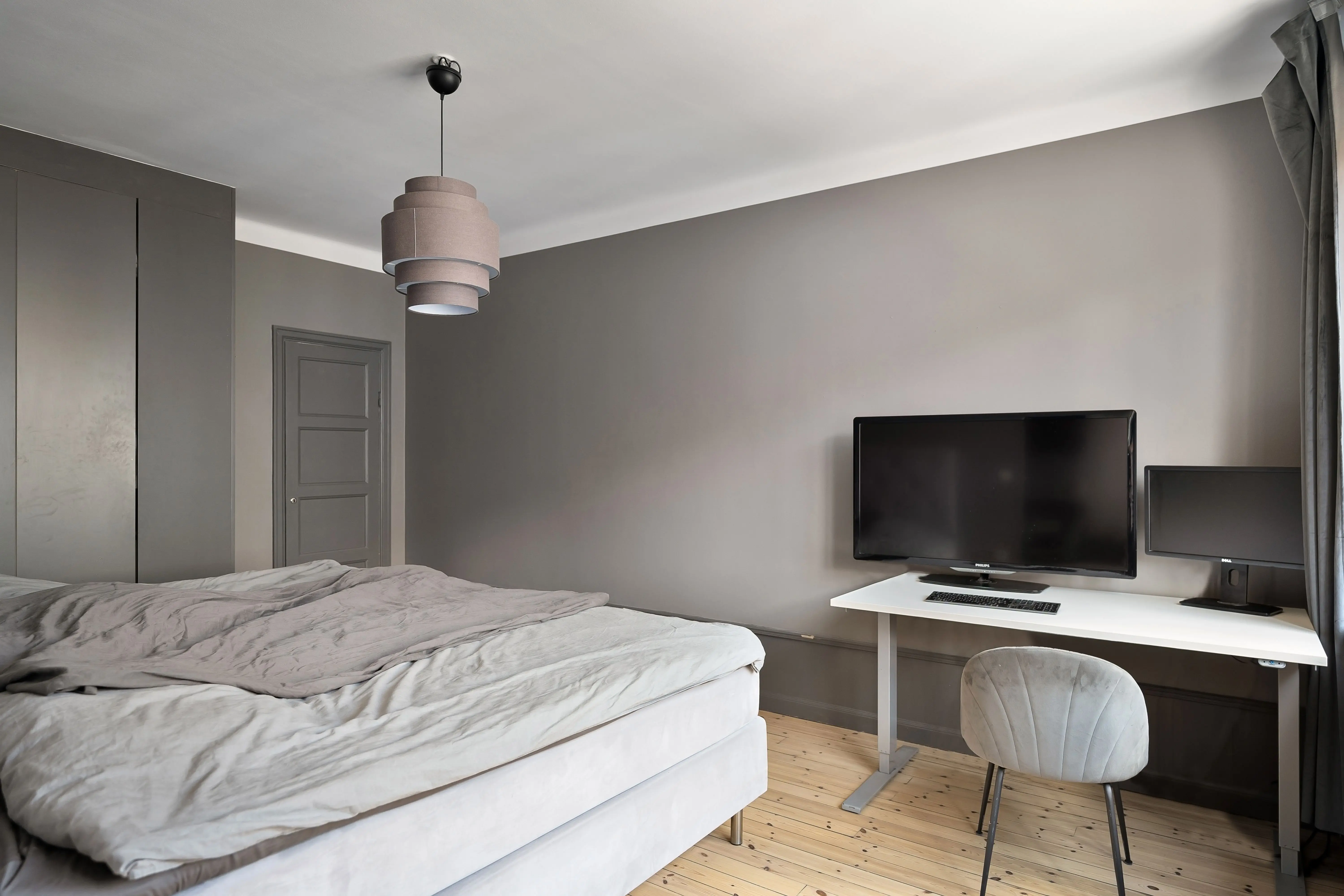 bed desk combo Sleek modern bedroom with a minimalist design featuring a computer workstation and gray walls.