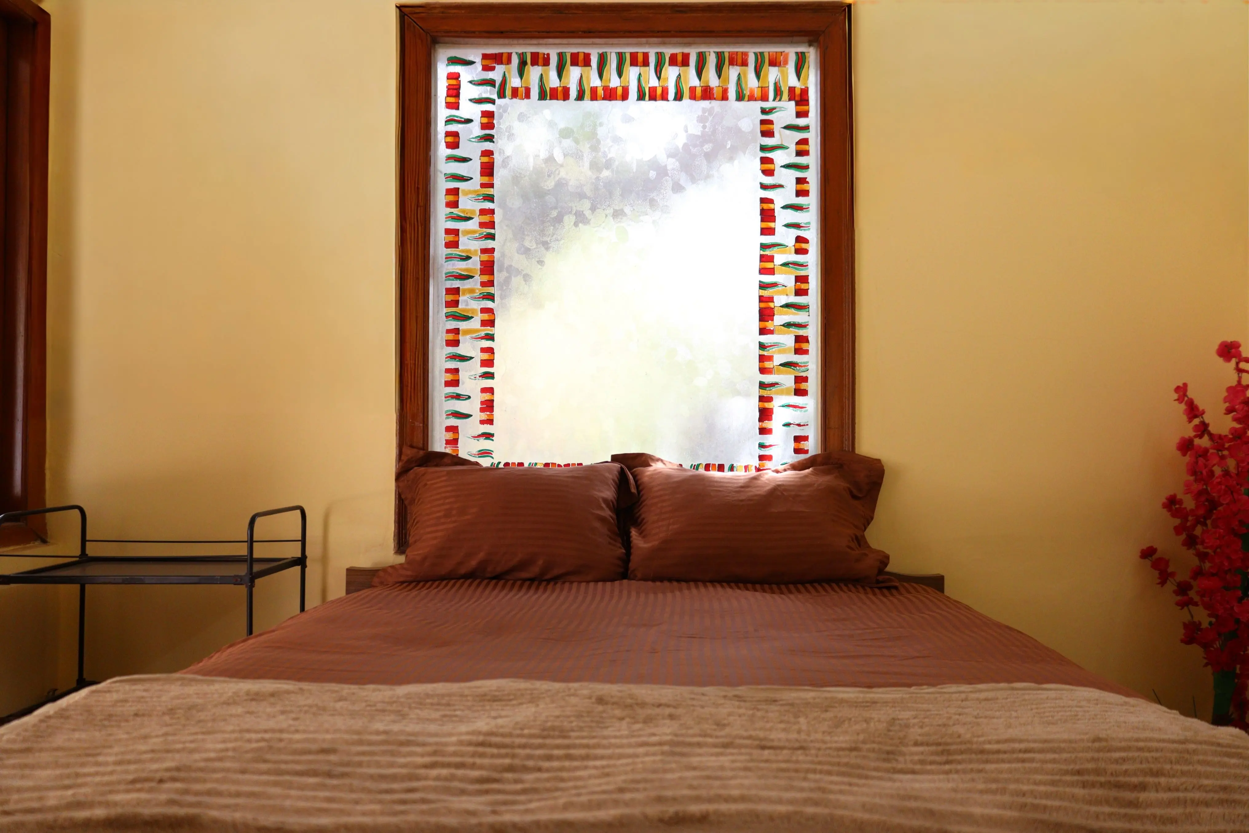 cinnamon slate color A warm and inviting bedroom with a decorative window and brown bedding in Ahmedabad, India.