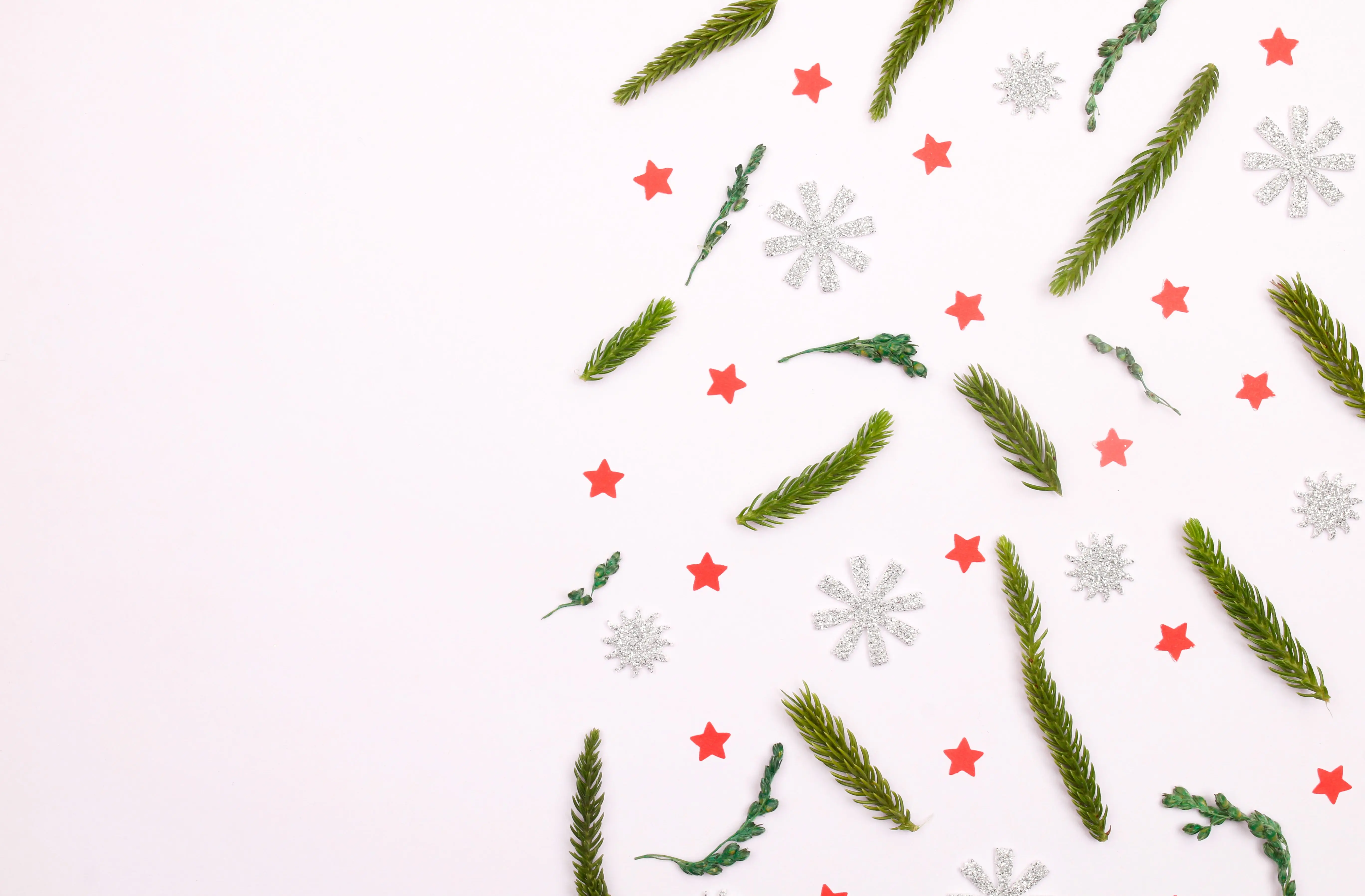 christmas handprint crafts Green fir branches, red stars, and snowflakes create a festive holiday flat lay.
