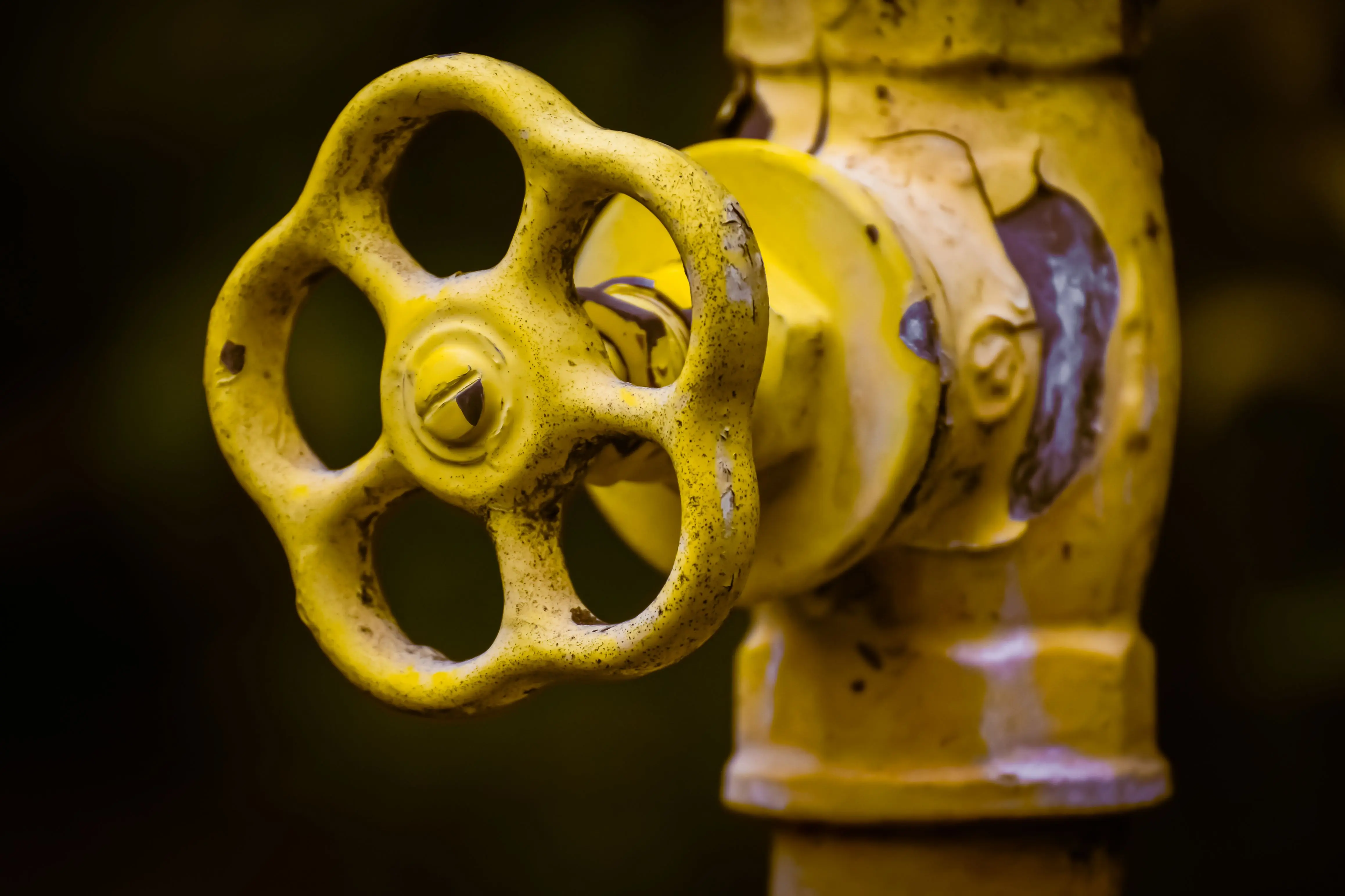 bathroom sink parts Close-up view of a rusty yellow shut-off valve, emphasizing industrial wear.