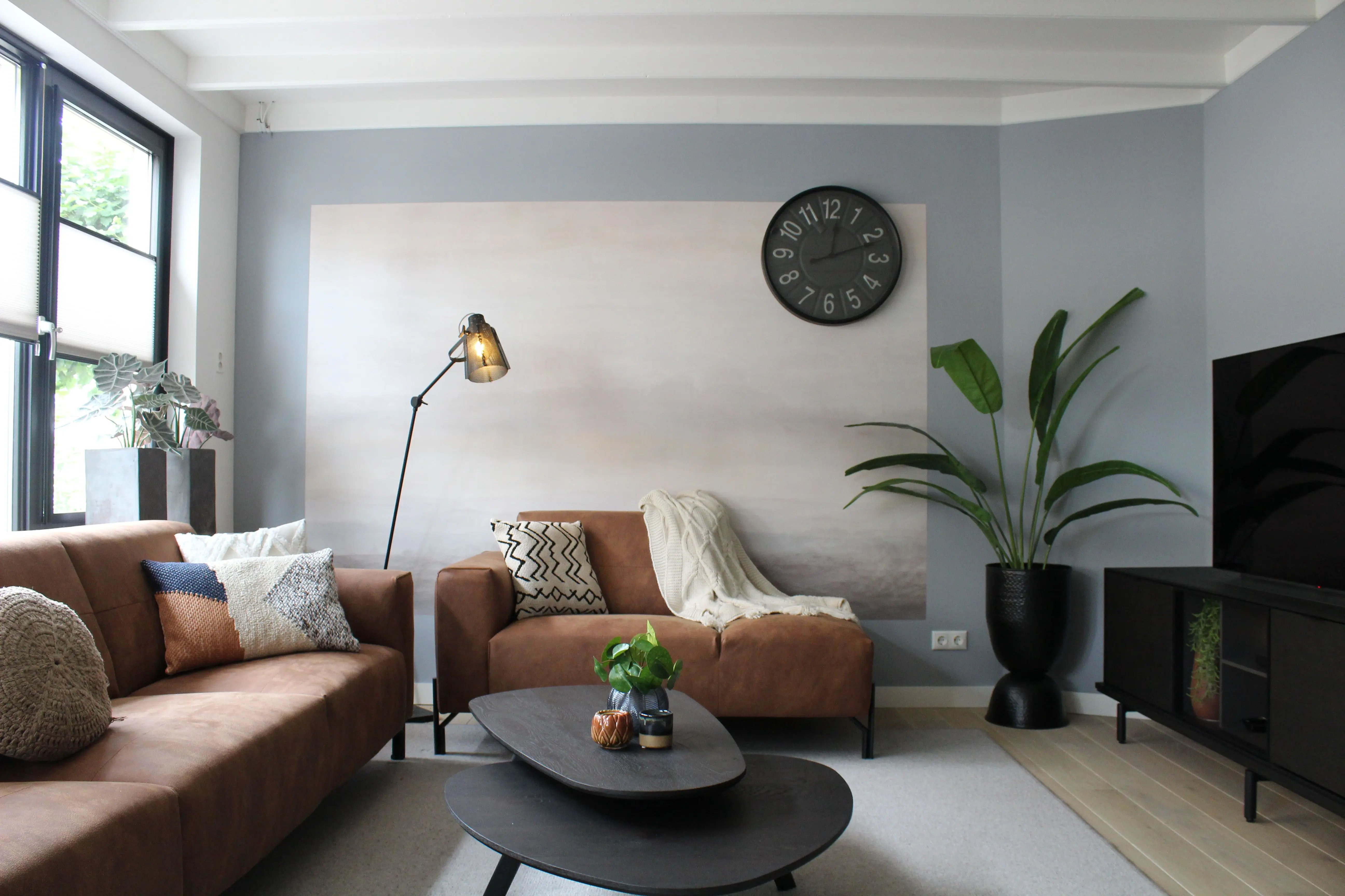 brown sectional sofa Stylish modern living room featuring cozy sofas, a wall clock, and elegant decor pieces.