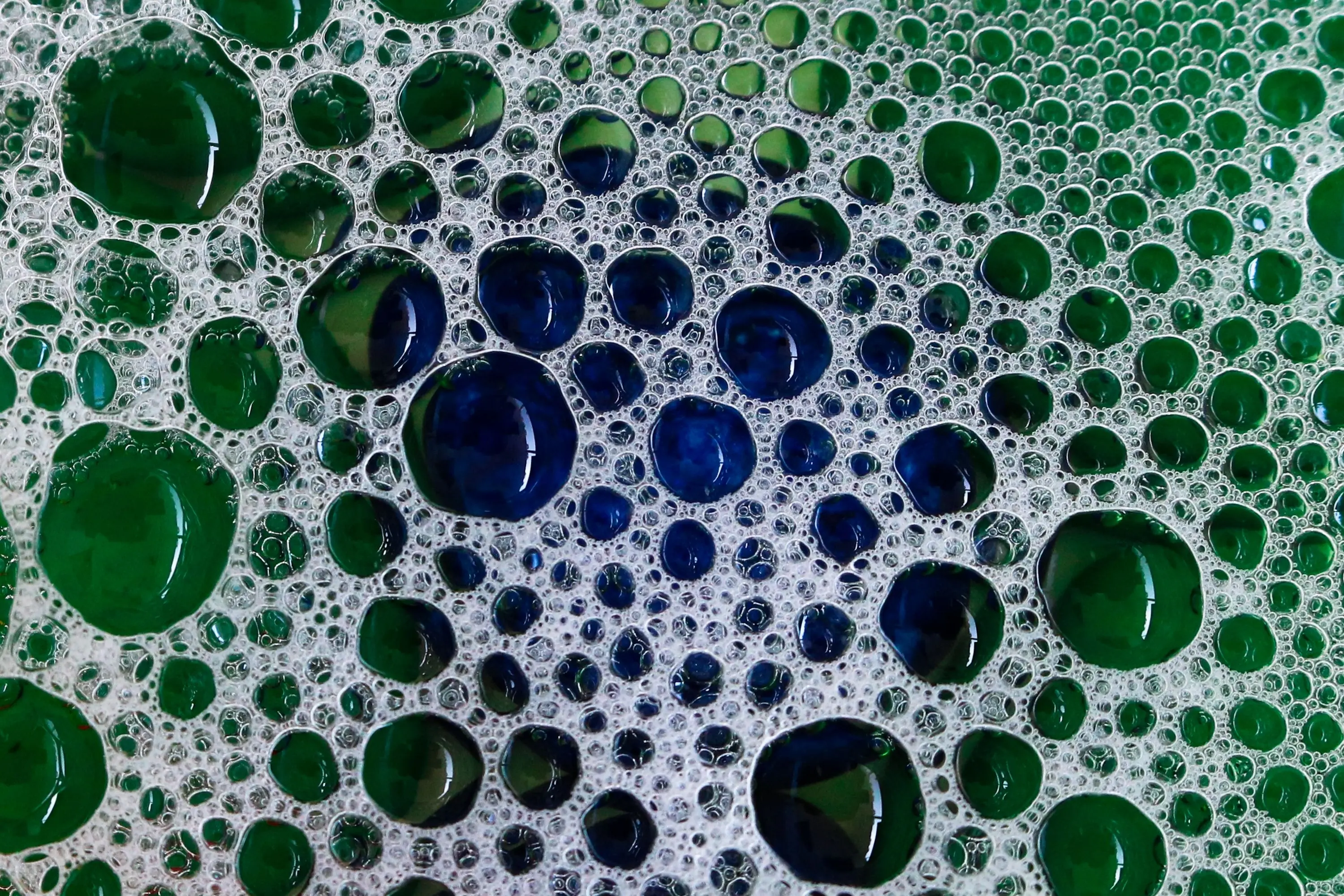 diy laundry detergent powder Close-up of vibrant soap bubbles creating a green and blue abstract pattern.
