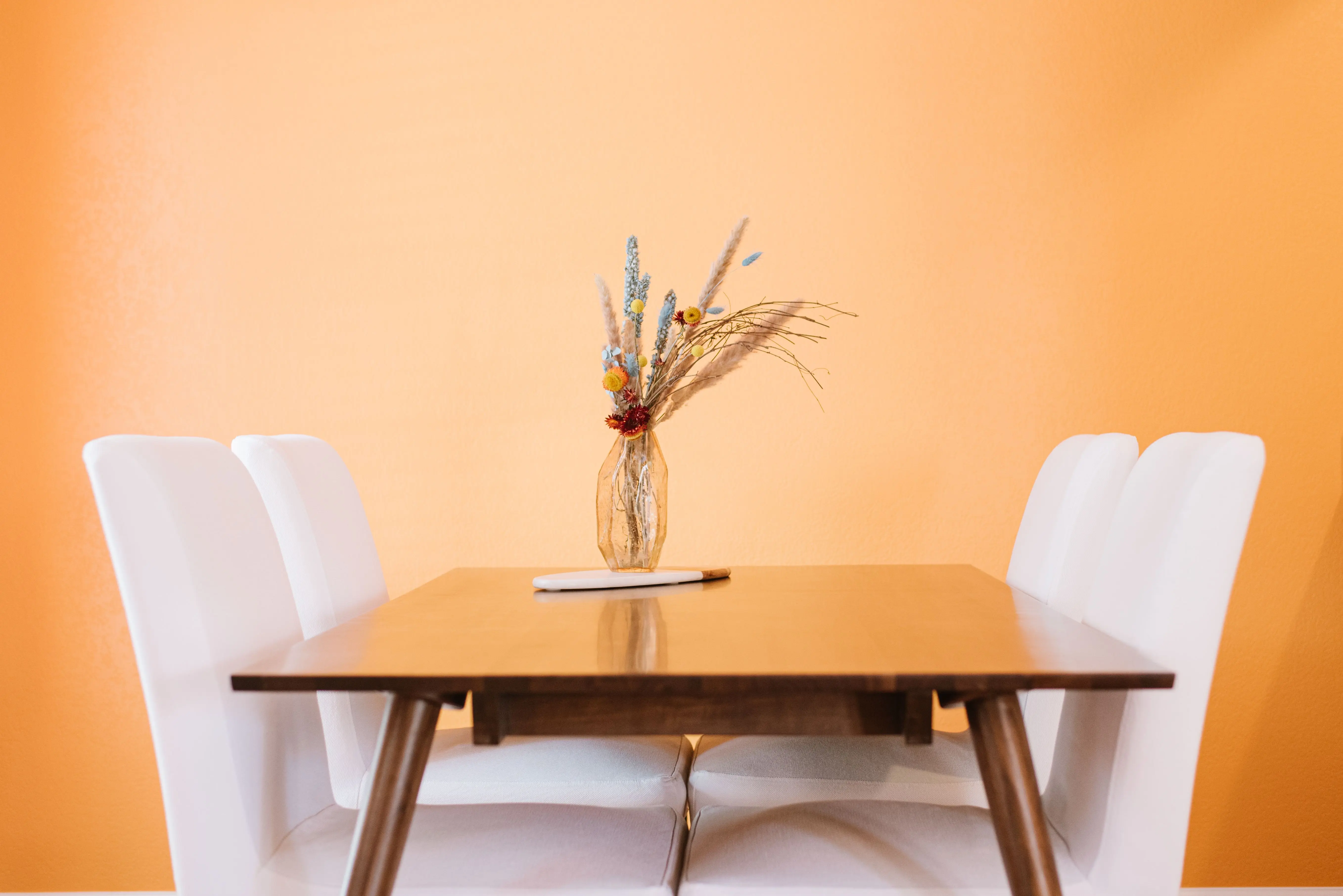 extension dining table Table with glass vase with various flowers and plants near chairs in light room with yellow wall