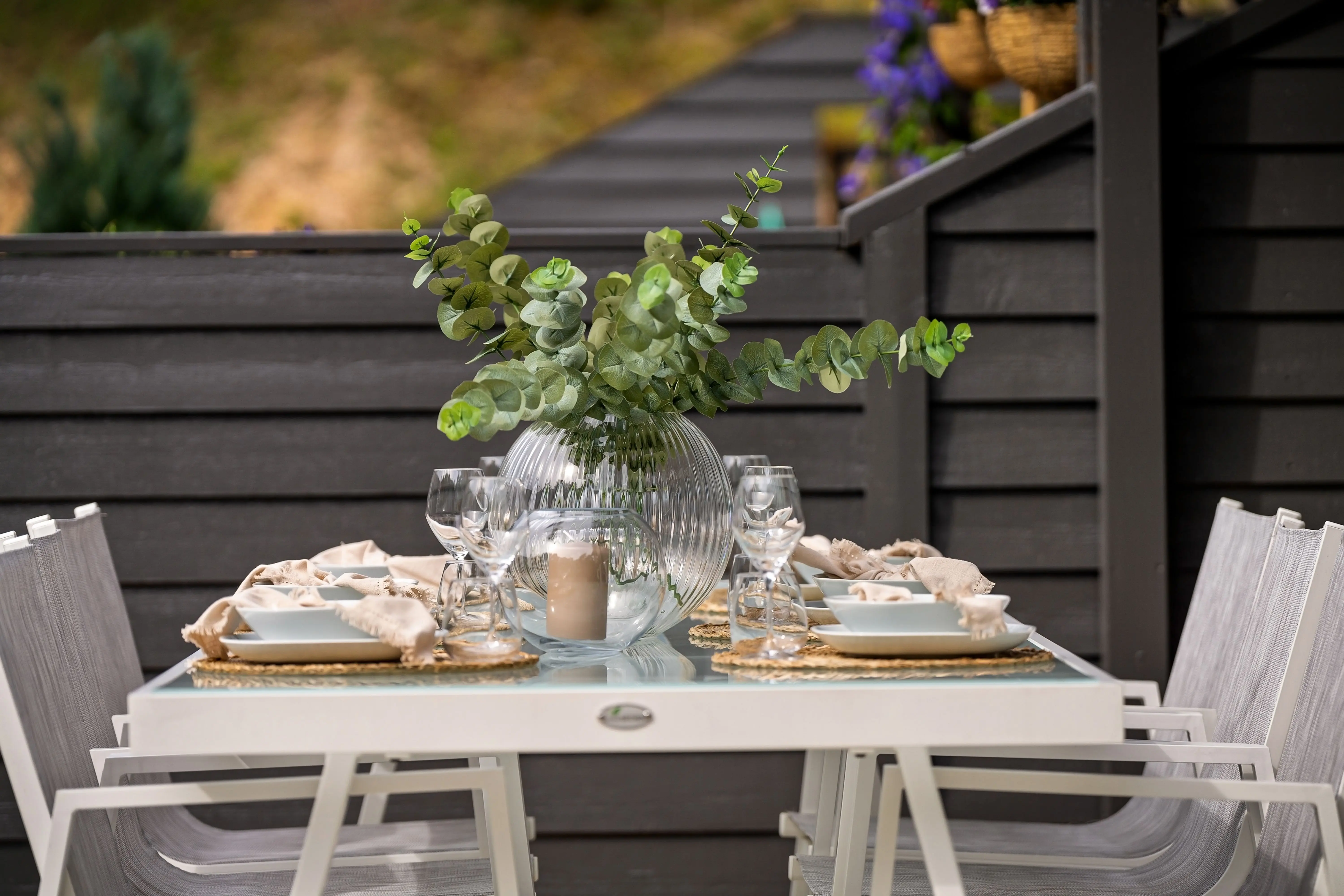 extension table Chic outdoor dining table with eucalyptus centerpiece, perfect for alfresco gatherings.