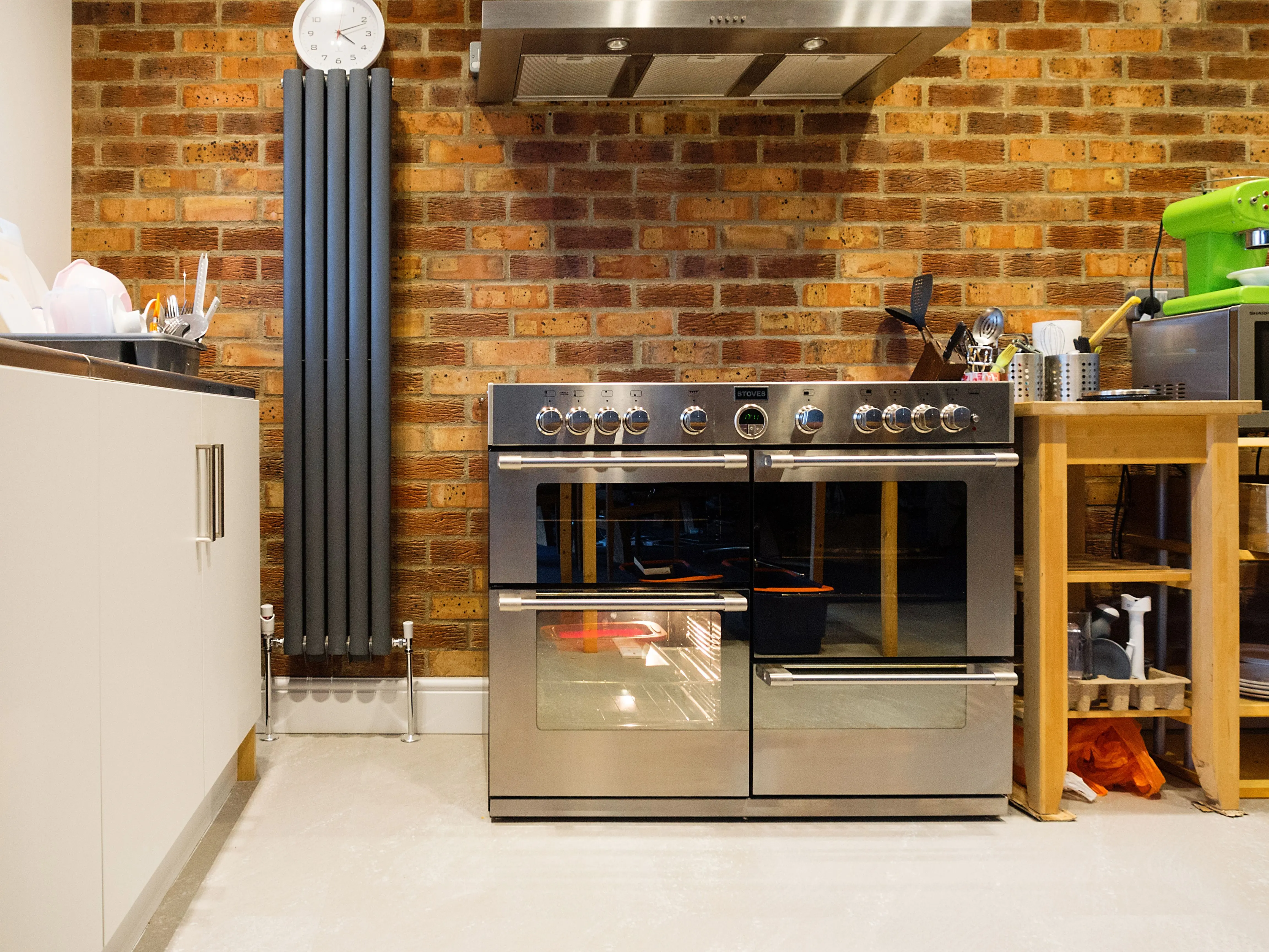 extension table Stylish kitchen featuring a stainless steel oven, exposed brick wall, and contemporary appliances.