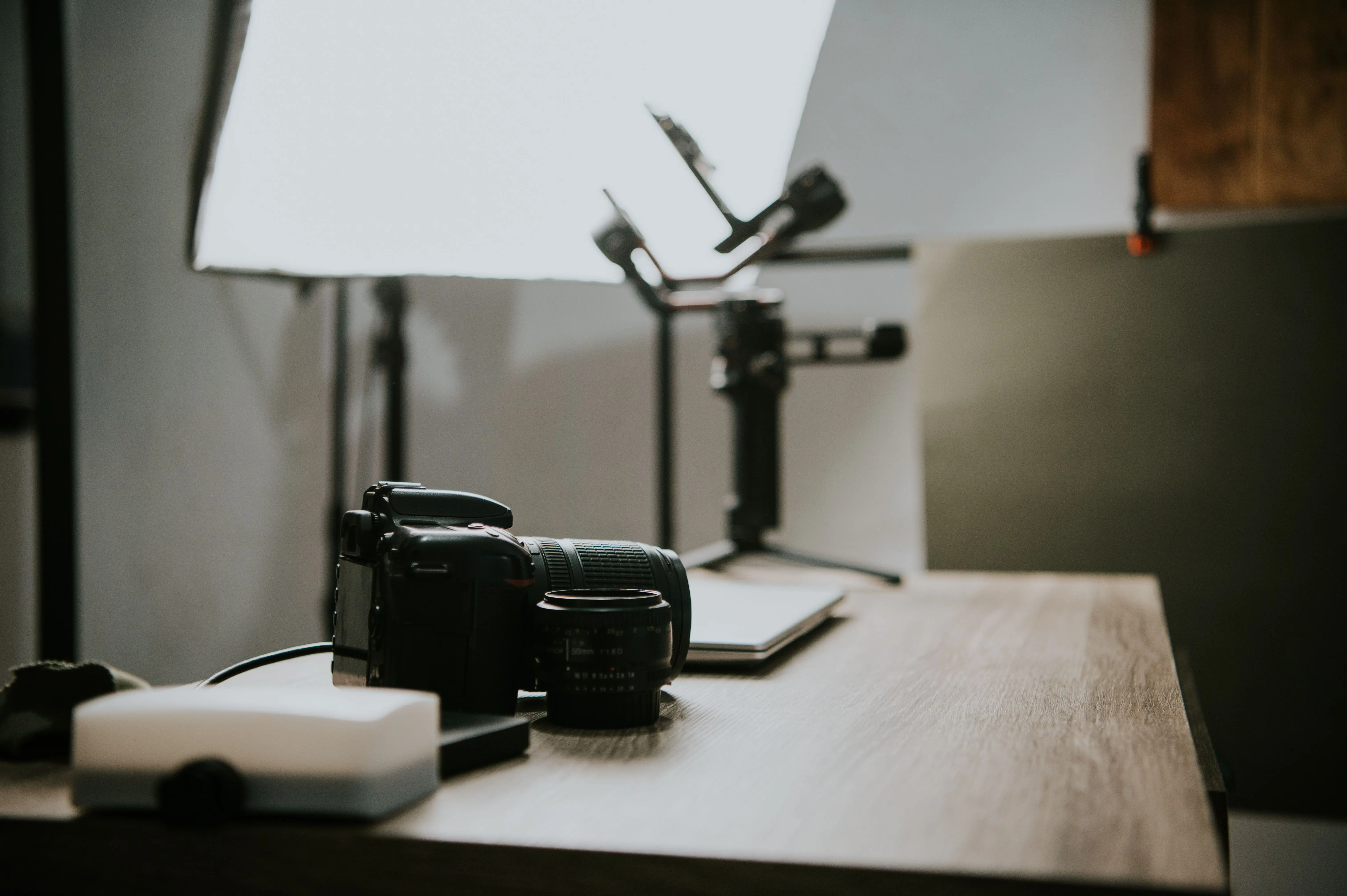 extension table Close-up of a DSLR camera and lens on a wooden table in a studio setting, perfect for photography-themed content.