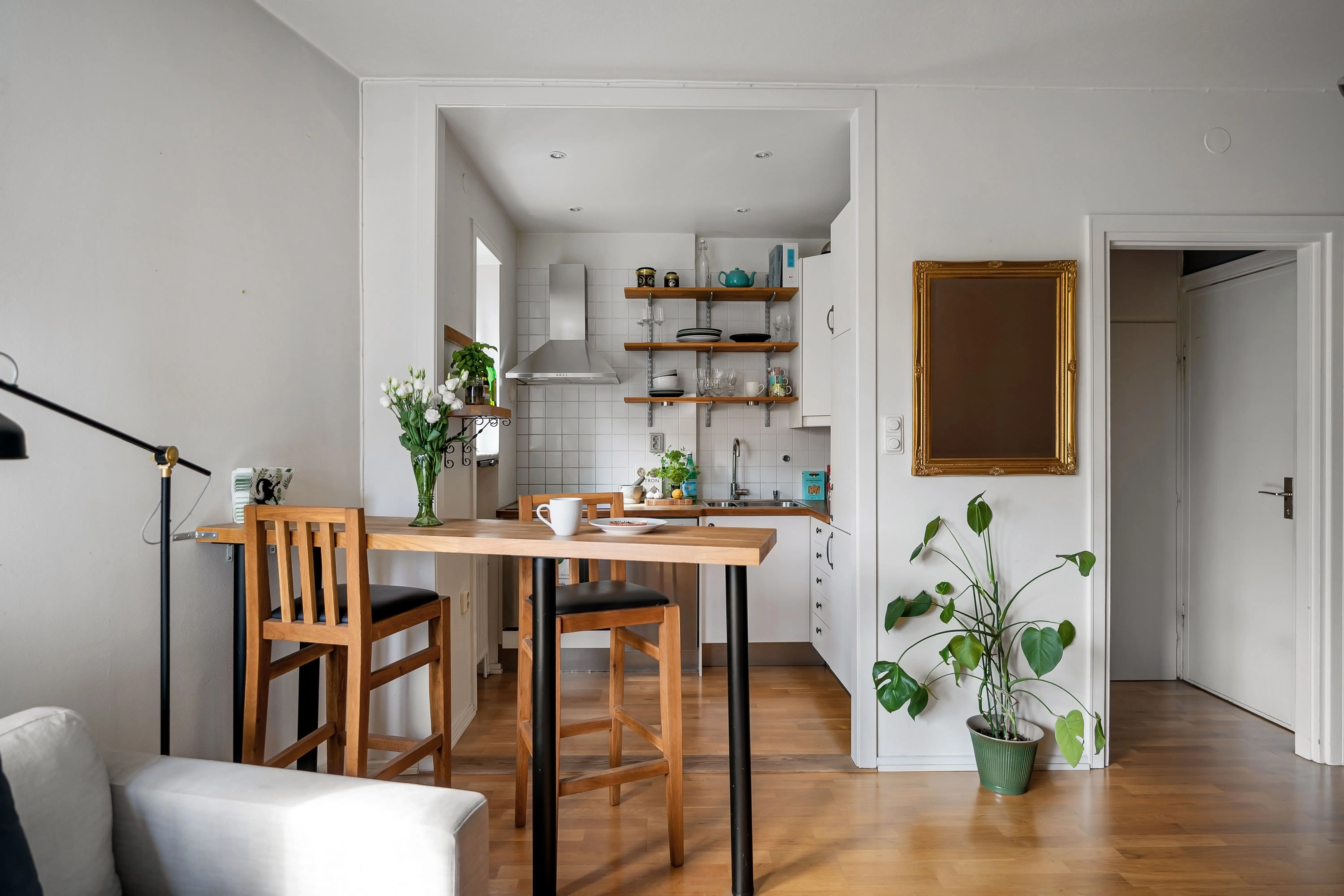 extension table A cozy kitchen and dining area with wooden furniture and green plants creating a modern Scandinavian design.