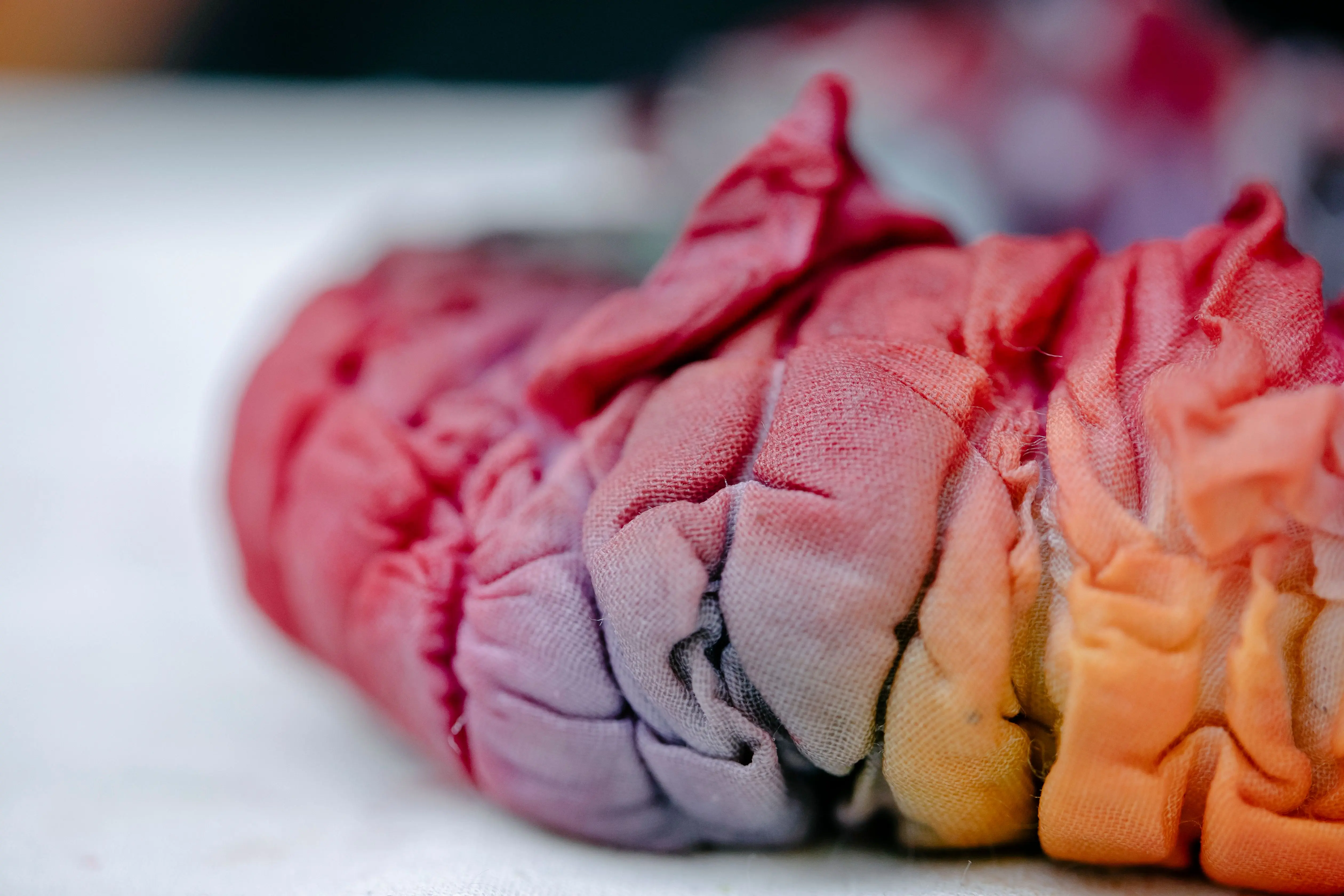 cool tie dye patterns Focused shot of colorful, creased tie-dye fabric, showcasing its vibrant spectrum and texture.
